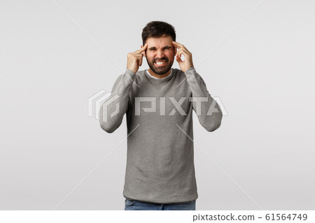 Hangover, holidays and healthcare concept. Irritated and bothered adult bearded man, grimacing from pain, clench teeth, touching temples, massage head as feeling huge headache, suffer migraine Hangover, holidays and healthcare concept. Irritated and bothered adult bearded man, grimacing from pain, clench teeth, touching temples, massage head as feeling huge headache, suffer migraine 61564749
