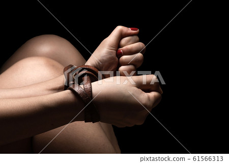 Woman tied up with leather belt in emotional 61566313
