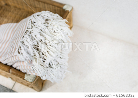 White stripe cotton towels in whicker basket against white wall. White stripe cotton towels in whicker basket against white wall. 61568352