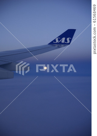 COPENHAGEN, DENMARK - NOV 24th, 2018: View of the moon and the wing from window of a flying plane, wingview of an airplane COPENHAGEN, DENMARK - NOV 24th, 2018: View of the moon and the wing from window of a flying plane, wingview of an airplane 61568469