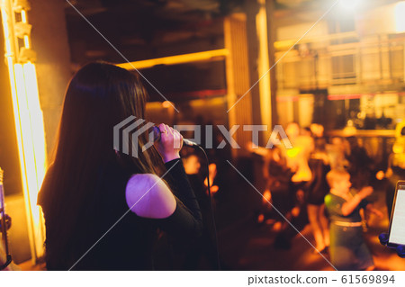 Beautiful Singing Girl. Beauty Glamor fashion Woman with Microphone over Blinking bokeh night background. Glamour Model Singer. Karaoke song. Karaoke party. Beautiful Singing Girl. Beauty Glamor fashion Woman with Microphone over Blinking bokeh night background. Glamour Model Singer. Karaoke song. Karaoke party. 61569894