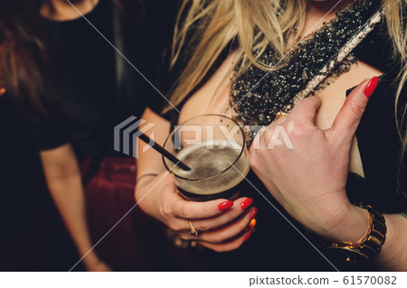Decollete, female breast. Neckline black dress and fur collar. 61570082