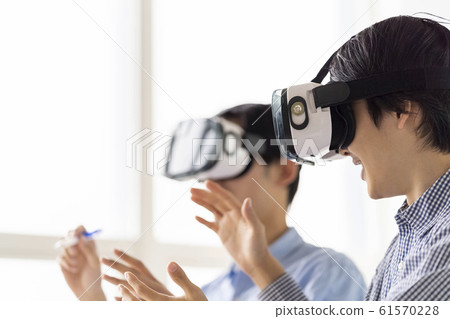 兩名男子通過VR護目鏡體驗3D最新5G技術並將其納入業務 兩名男子通過VR護目鏡體驗3D最新5G技術並將其納入業務 61570228