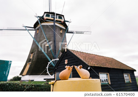 Two wooden mice couple sitting on a metal yellow round cylinder Two wooden mice couple sitting on a metal yellow round cylinder 61570400