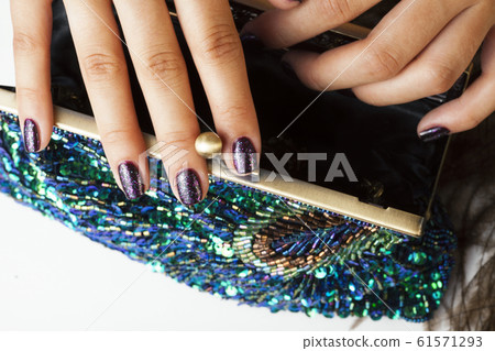 woman hands with shiny manicure holding little purse peacok feather, cosmetic and fashion people concept 61571293