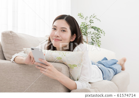 Young woman, smartphone, sofa 61574714