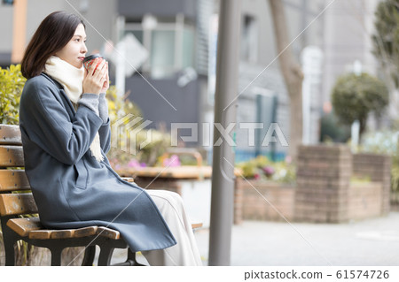 Young woman winter tilt cup coffee 61574726