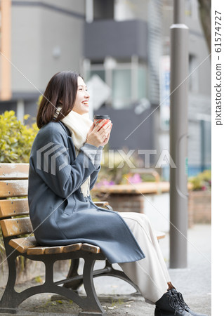 Young woman winter tilt cup coffee 61574727