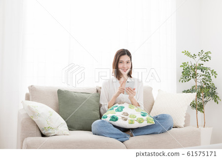 Young woman smartphone smartphone sofa seat Young woman smartphone smartphone sofa seat 61575171