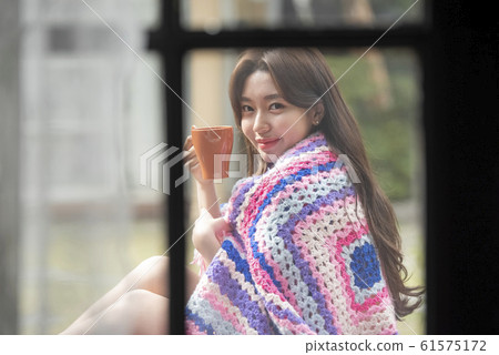 Woman with mug outdoors 61575172