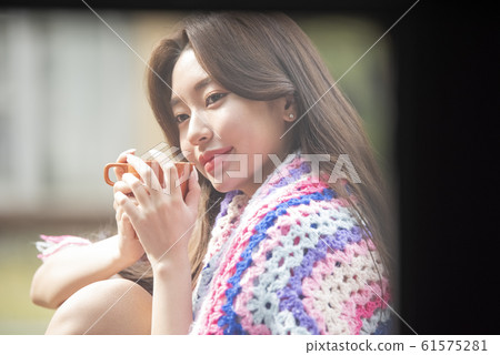 Woman with mug outdoors 61575281