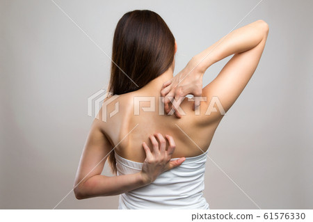 Woman scratching her back 61576330