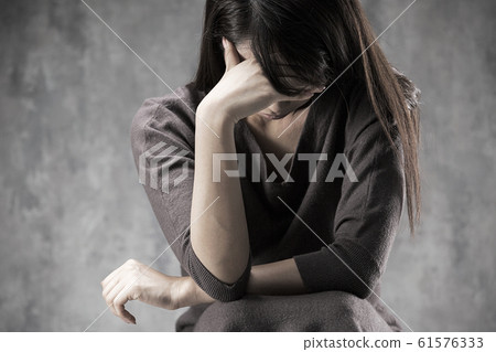 A woman holding her head. 61576333