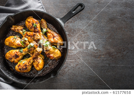 Roasted chicken legs in pan with herbs - close up 61577658