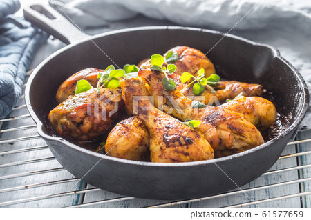 Roasted chicken legs in pan with herbs - close up 61577659