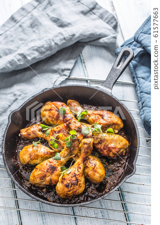 Roasted chicken legs in pan with herbs - close up 61577663
