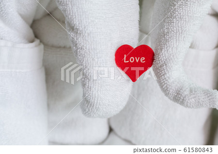 a wooden red heart holding an elephant figurine of a wooden red heart holding an elephant figurine of 61580843