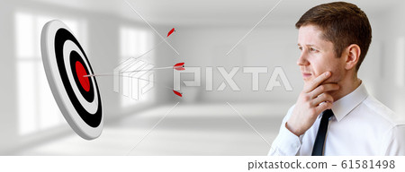 Businessman looks on archery target with arrows. Businessman looks on archery target with arrows. 61581498