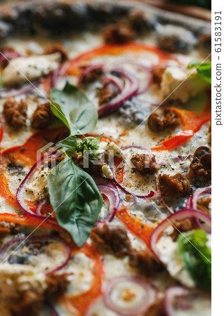 A basil leaf close up on a pizza. A basil leaf close up on a pizza. 61583191