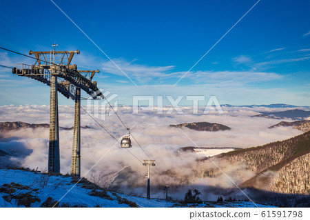 Winter mountain landscape at a sunny day with fog 61591798