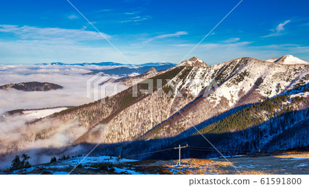 Winter mountain landscape at a sunny day with fog 61591800
