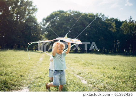 Cute little child in a summer field with a Kite 61592426