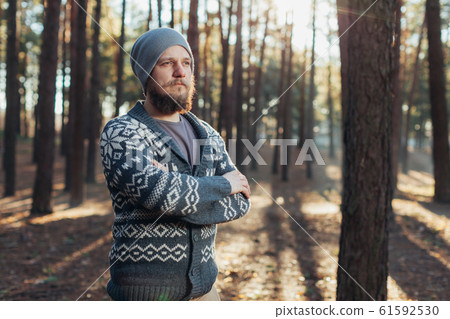 a young man with a beard walks in a pine forest. a young man with a beard walks in a pine forest. 61592530