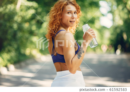 Beautiful woman training in a summer park 61592583
