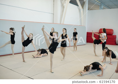 Doing stretching exercises at cheerleading training 61594170