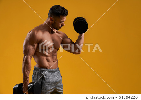 Athletic young man doing exercise for biceps Athletic young man doing exercise for biceps 61594226