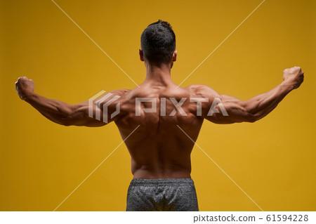 Muscular young man showing perfect biceps Muscular young man showing perfect biceps 61594228