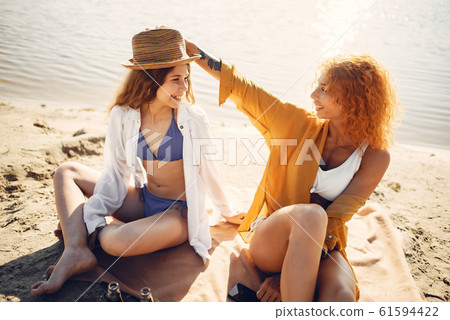 Sporty mother with cute daughter walking near lake 61594422