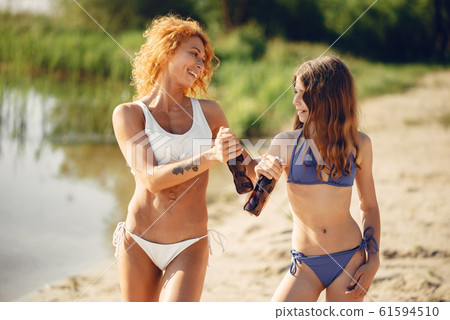 Sporty mother with cute daughter walking near lake Sporty mother with cute daughter walking near lake 61594510