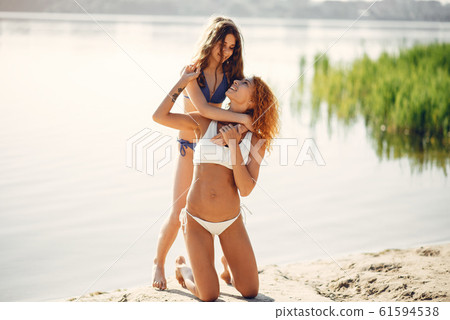 Sporty mother with cute daughter walking near lake 61594538