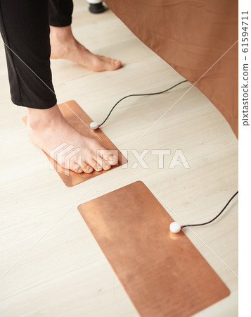 Image of stepping on electrodes of electro hand 61594711