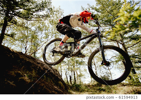 athlete rider riding forest trail 61594913