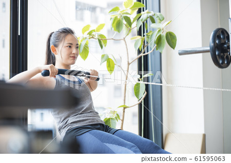 Woman training on rowing machine Woman training on rowing machine 61595063