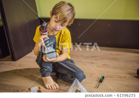Boy assembling furniture. Boy helping his dad at home. Happy Family concept Boy assembling furniture. Boy helping his dad at home. Happy Family concept 61596255