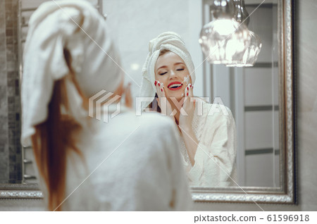 Beautiful woman standing in a bathroom Beautiful woman standing in a bathroom 61596918