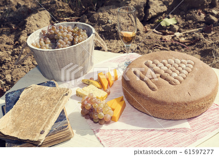 Autumn feast in a vineyard with ritual bread, cheese and white wine Autumn feast in a vineyard with ritual bread, cheese and white wine 61597277