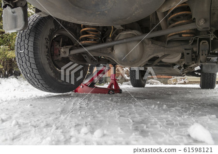 Car is lifted on a hydraulic Jack. Car is lifted on a hydraulic Jack. 61598121