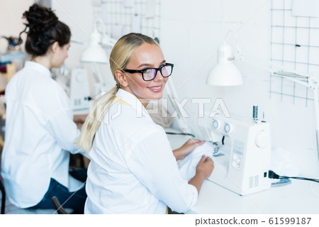 Blond woman at sewing machine 61599187