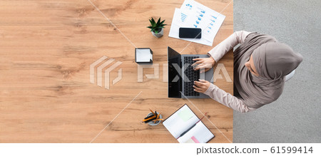 Top view of islamic woman working on laptop at workplace 61599414