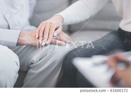 Unrecognizable elderly couple holding hands at doctor 61600172