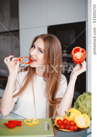 Beautiful woman prepare food in a kitchen Beautiful woman prepare food in a kitchen 61600250