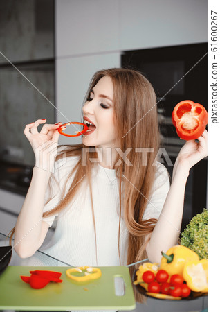 Beautiful woman prepare food in a kitchen Beautiful woman prepare food in a kitchen 61600267