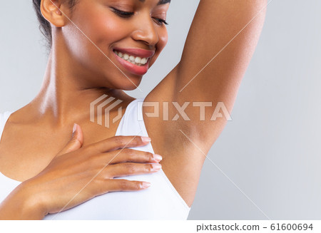 Close up of happy afro girl smelling her armpit Close up of happy afro girl smelling her armpit 61600694