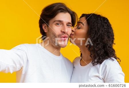 Loving Black Girlfriend Kissing Her Boyfriend's Cheek While They Taking Selfie 61600726