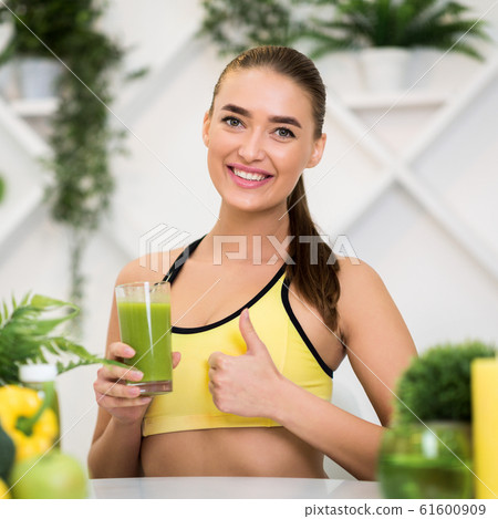 Healthy drink. Girl holding smoothie and showing thumb up 61600909