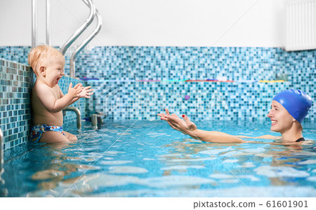 Mother with baby in swimming pool training Mother with baby in swimming pool training 61601901